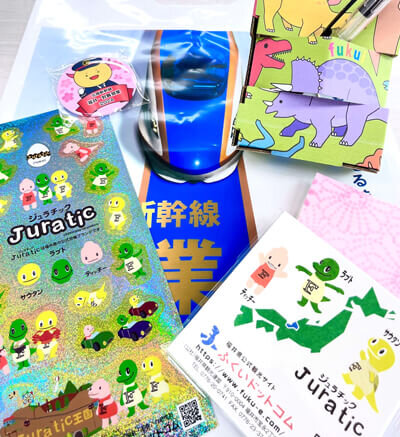 来場者プレゼントの和紙メモ帳、ジュラチックシール、はぴりゅう缶バッジ、恐竜ペン立ての画像