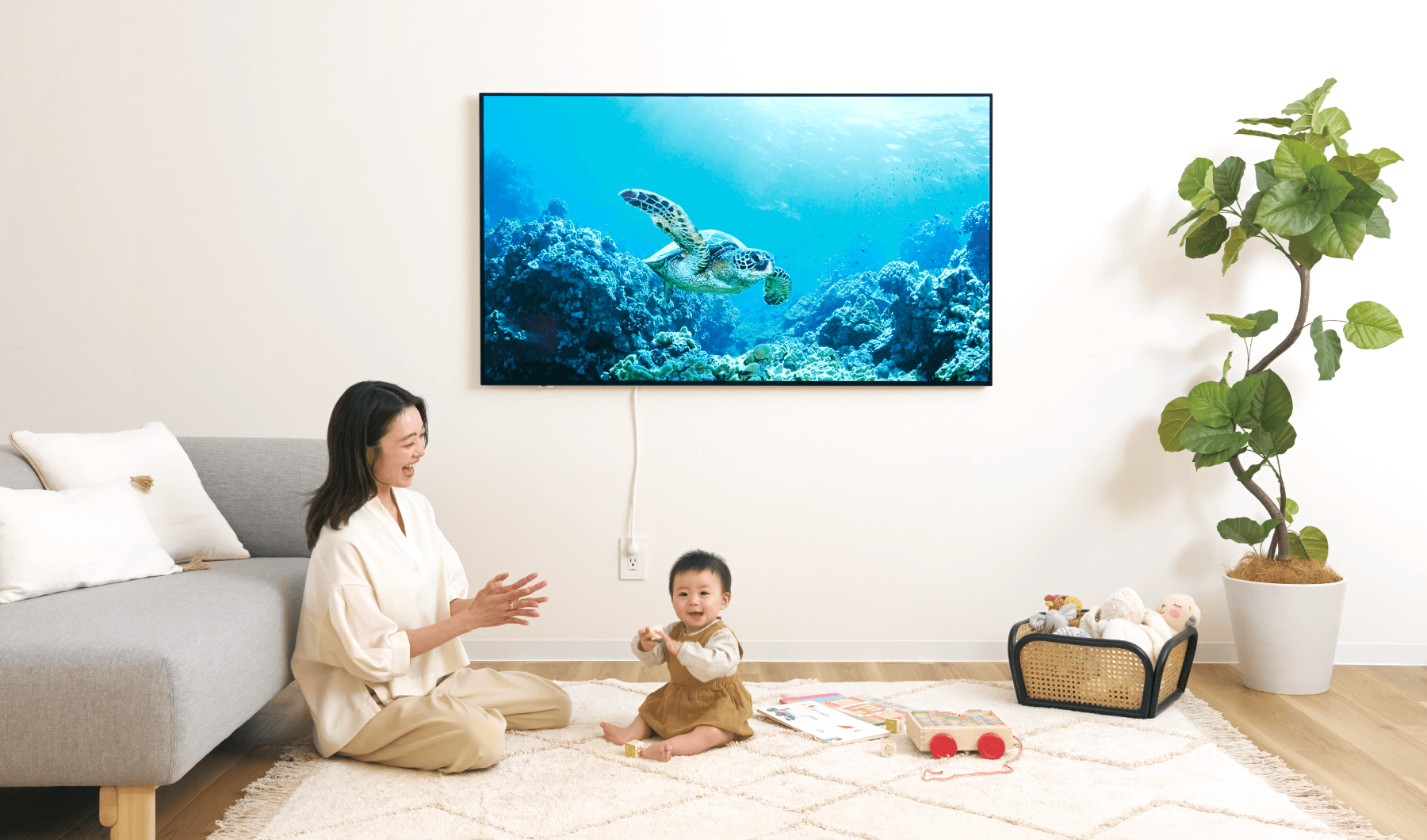 読者モデルの柚香さん、葵音（あおね）ちゃん（８ヵ月）が「ウォールフィットテレビ」の前で笑っている画像。