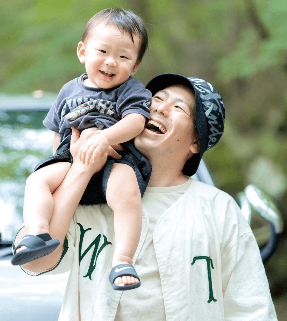こどもを肩にのせて笑顔のパパと子どもの画像