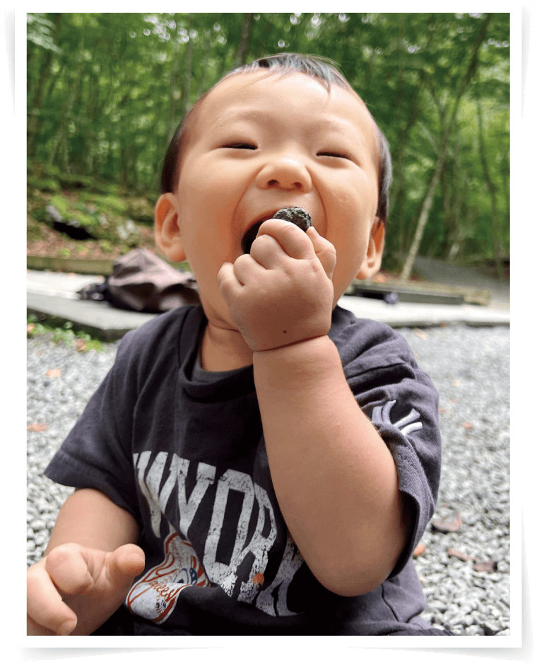 手づかみでおいしそうに食べる子どもの画像