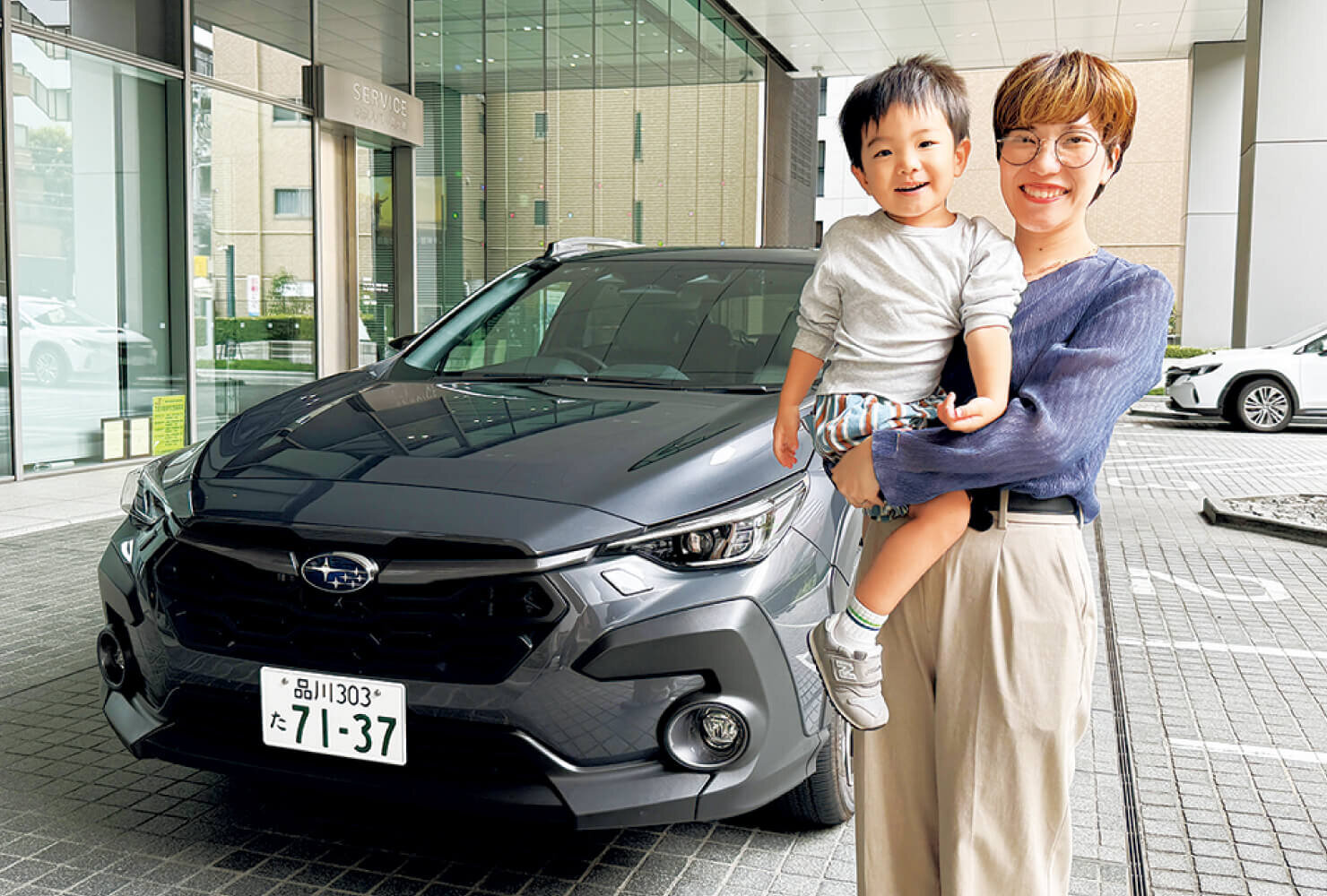  SUBARUのクロストレックの前に笑顔で立つママと男の子の画像
