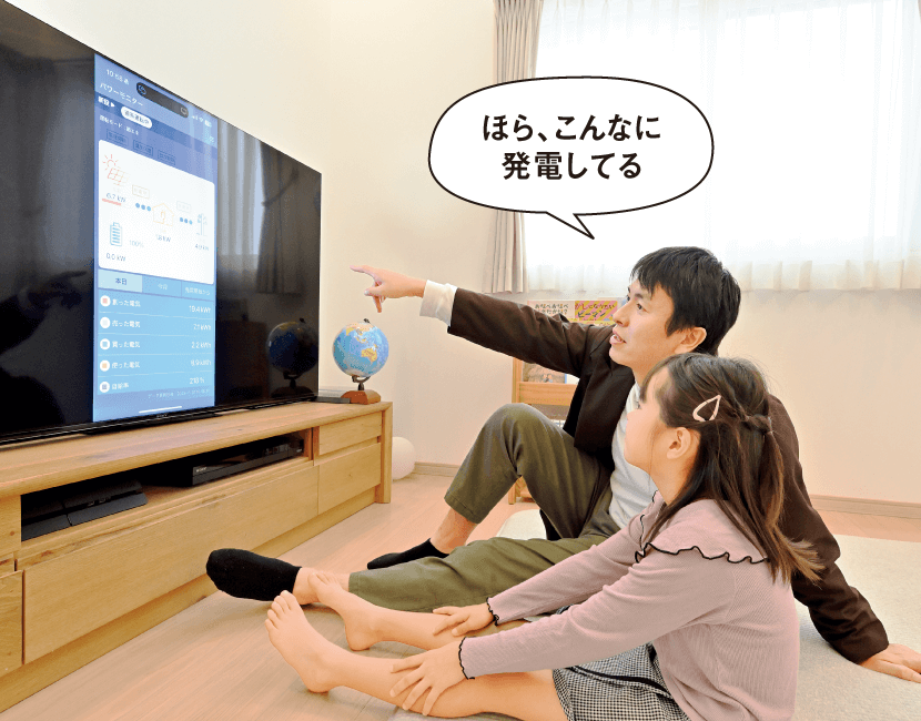 Yさんパパが長女のYちゃんに専用アプリの画面をみせながら「ほら、こんなに発電してる」と話しかけている画像